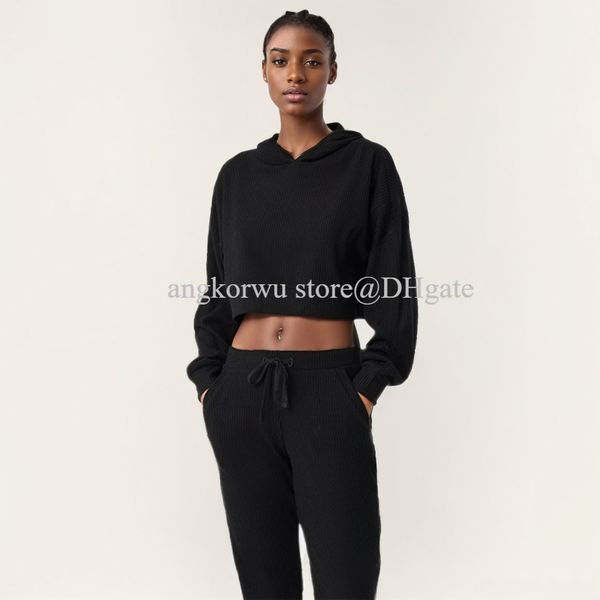 A stylish women's yoga set featuring a cropped hoodie and ribbed knit sweatpants for relaxed fitness wear from studio to street