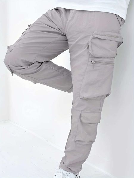 Men's lightweight slim-fit pleated cargo pants with waterless-wash fabric, asymmetric pockets, and cuff in black and light grey